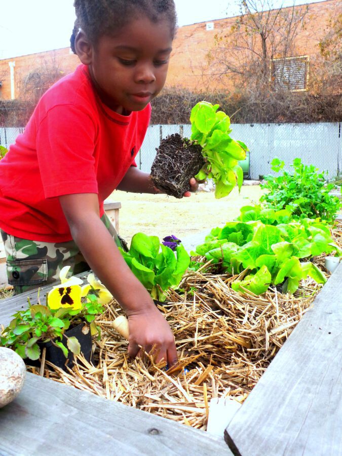 Photo of black student playing in garden at Vogel Alcove