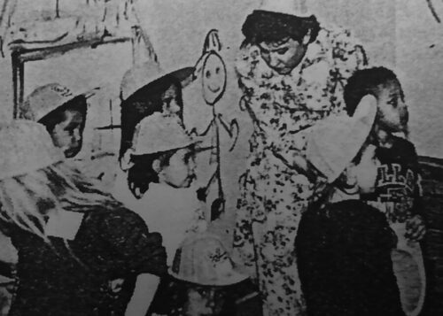 black and white news clipping of teacher with students almost 35 years ago