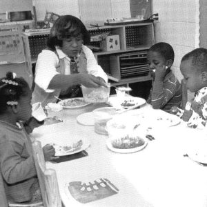 Teacher and students sitting at table almost 35 years ago